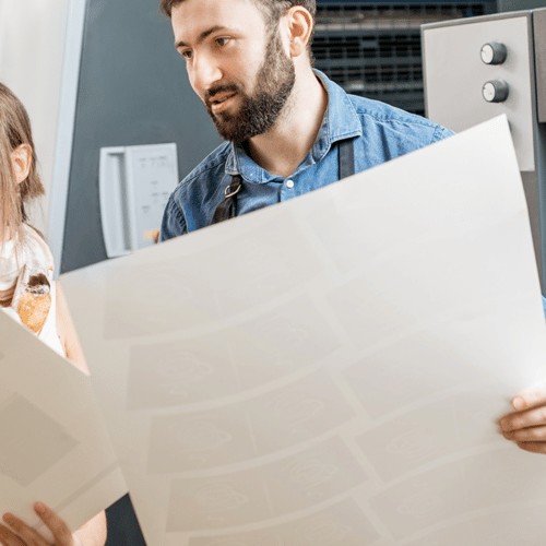 men and woman holding large format printed posters